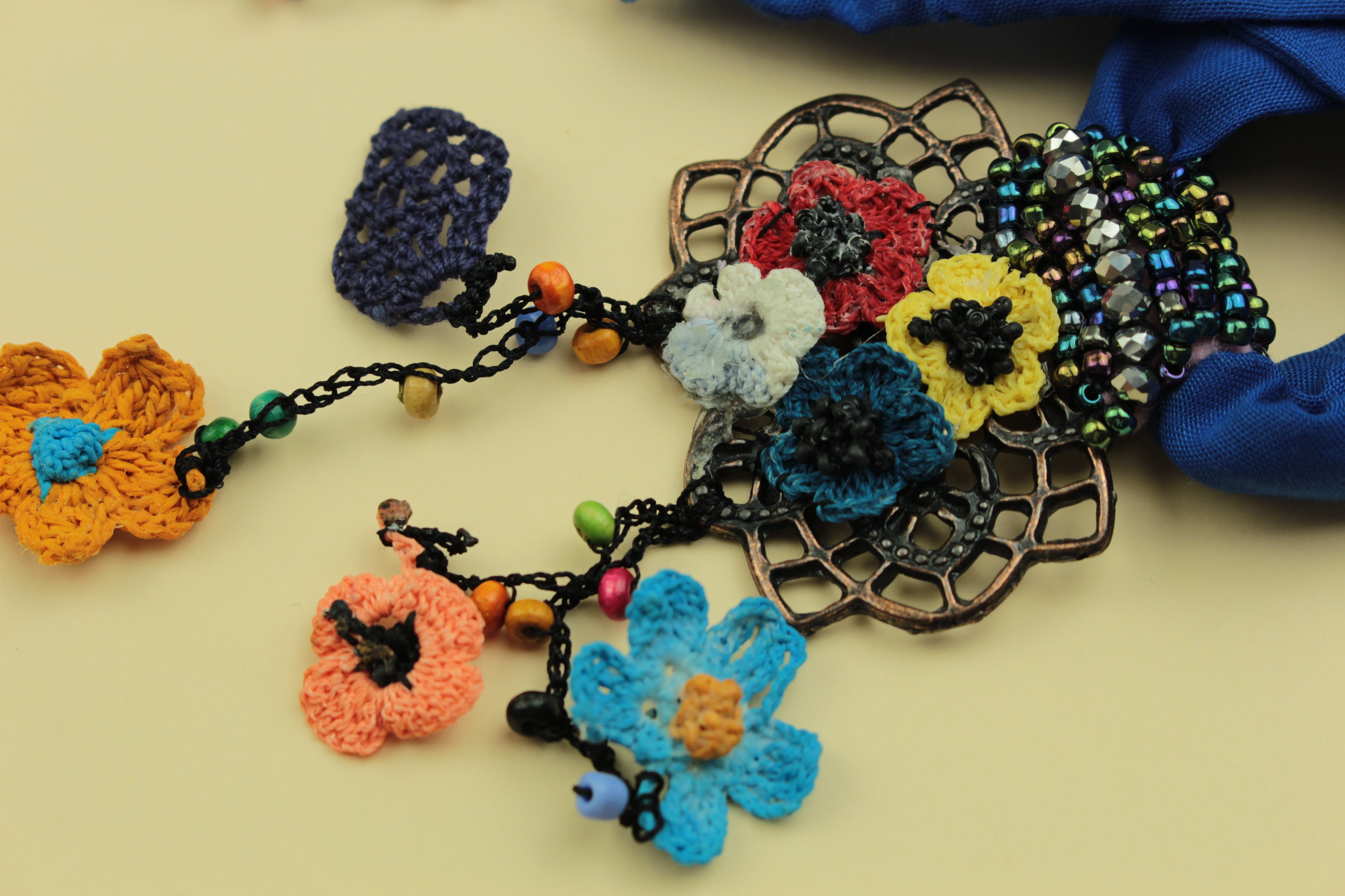 Boho blue crochet floral scarf necklace on a warm cream background, handmade in Tauranga