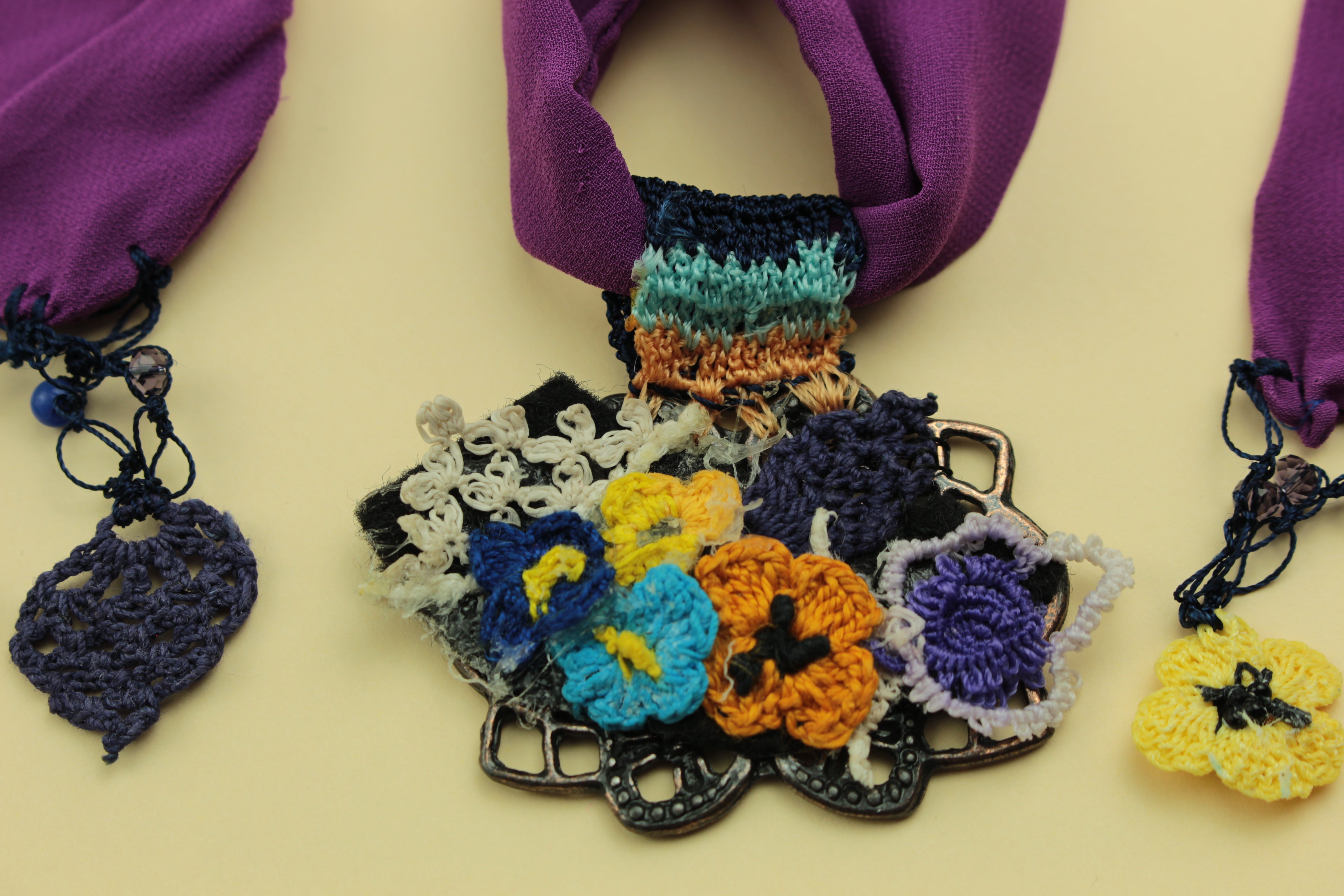 Floral crochet scarf necklace on a warm cream background, handmade in Tauranga