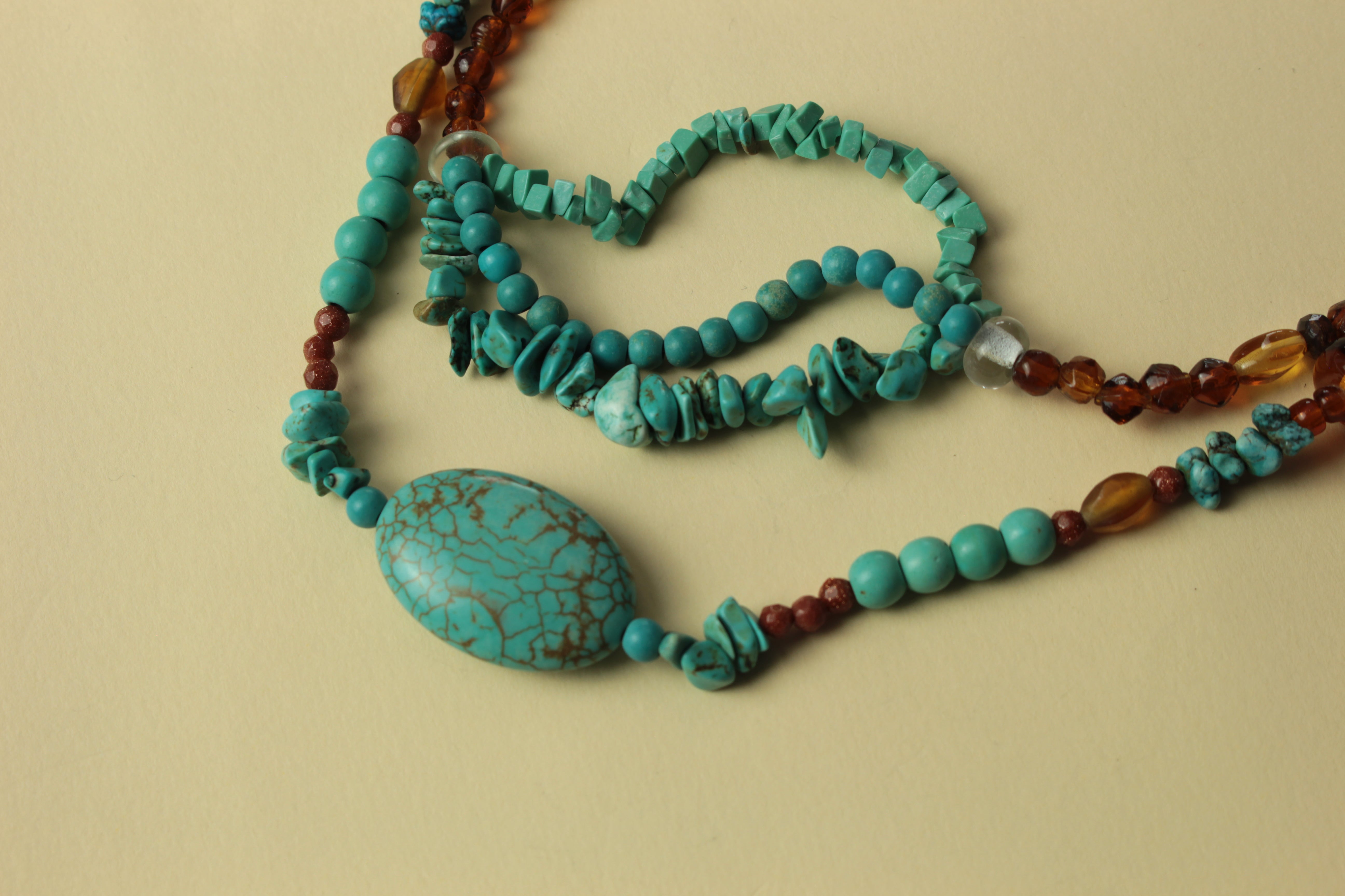 Natural turquoise stone multi-layer necklace on a warm cream background, handmade in Tauranga