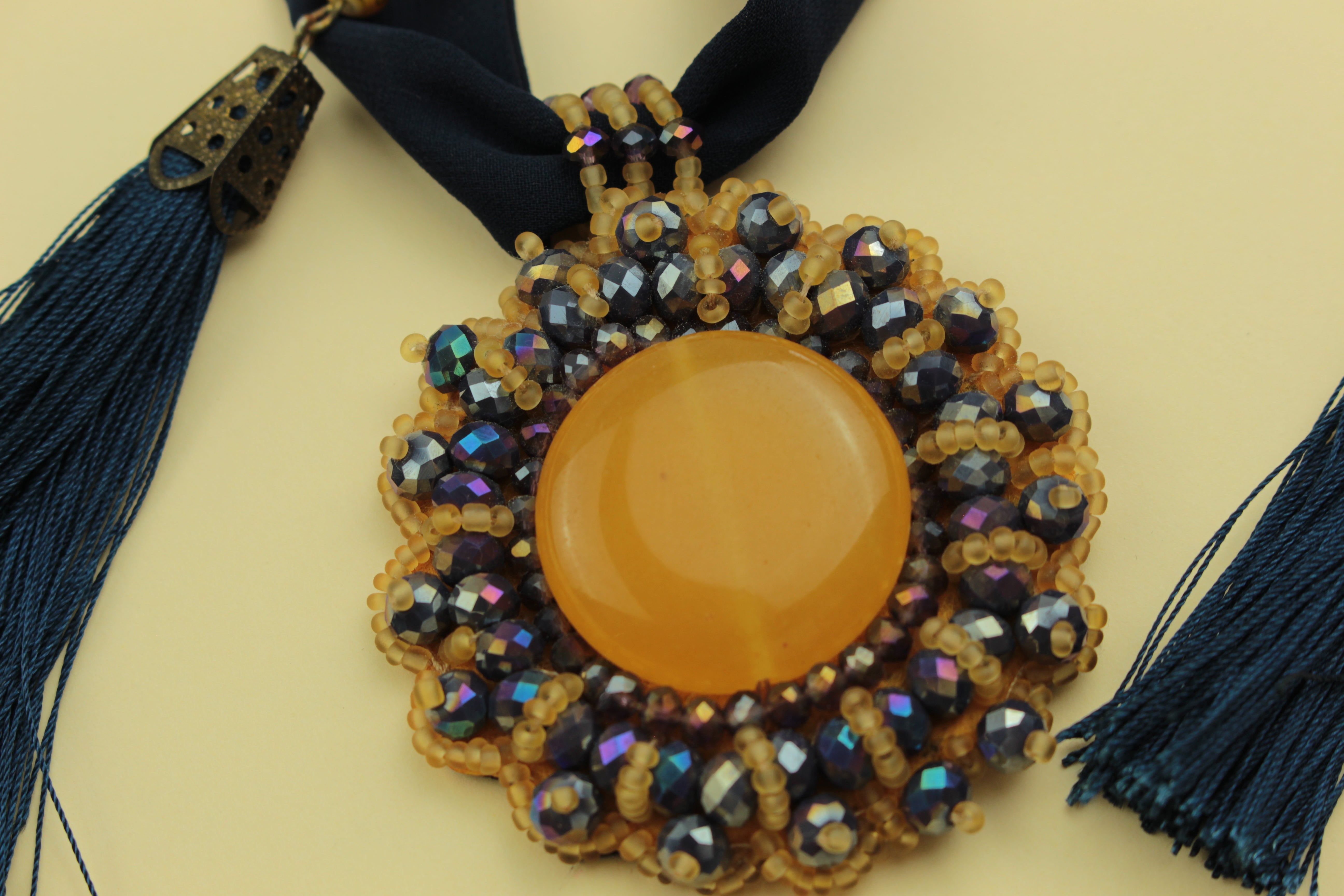 Sun glow statement tassel scarf necklace on a warm cream background, handmade in Tauranga